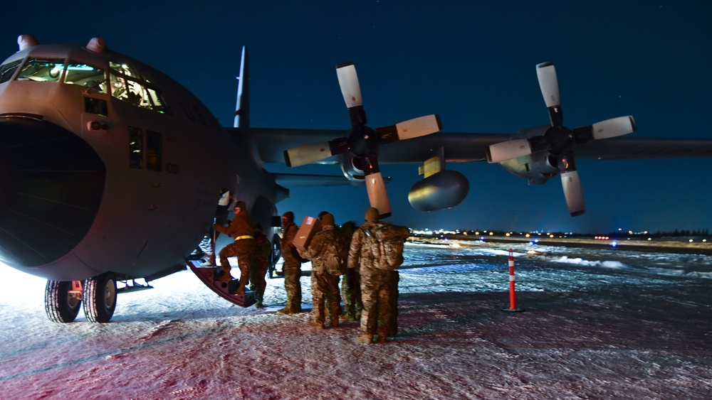 U.S. Air Force Airmen from the 148th Fighter Wing step onto a C-130 in Yellowknife, Canada preparing to forward-deploy