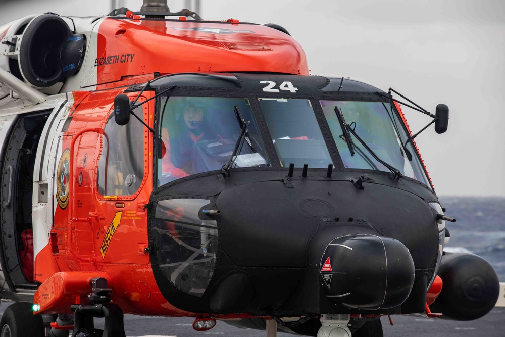 U.S. Coast Guard helicopter refuels aboard USS Arlington after a medical evacuation