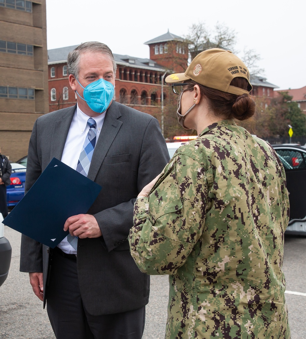 Acting Secretary of the Navy Thomas W. Harker is presented a memento by Shipyard Commander Capt. Dianna Wolfson at the conclusion of his visit to Norfolk Naval Shipyard March 17