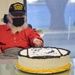 Retired Major Irving Torres-Rivera cuts the cake at commemoration ceremony