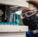Scientist Keshia Capers places sample vial into an auto sampler tray for instrumental analysis