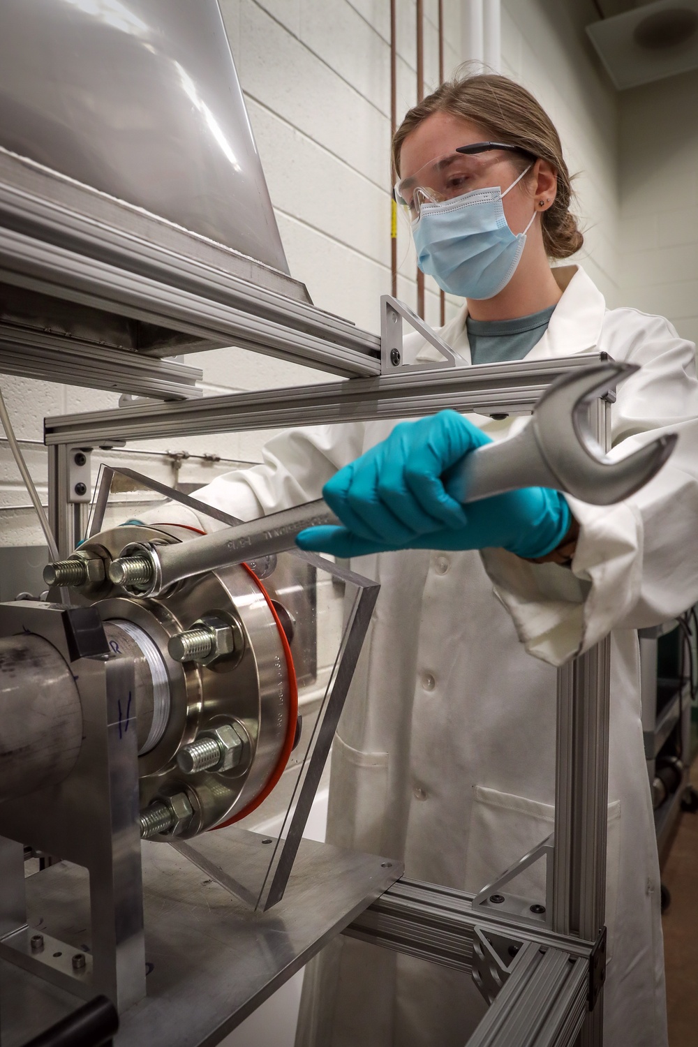 Chemist Emma Skekel replaces an optical window on the newly integrated dust combustion system