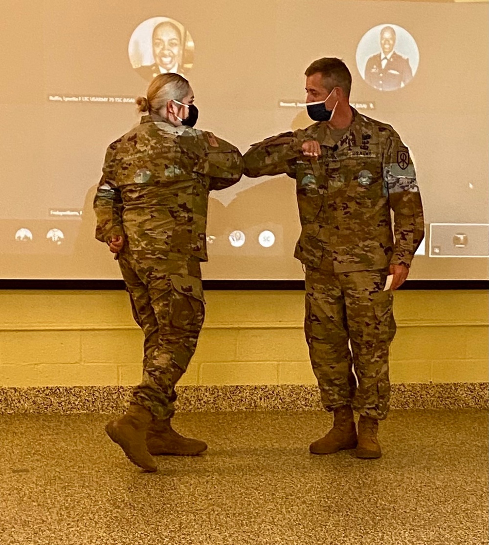 Brig. Gen. Christopher Barra, commander of the 451st Sustainment Command (Expeditionary), presents his commander’s coin