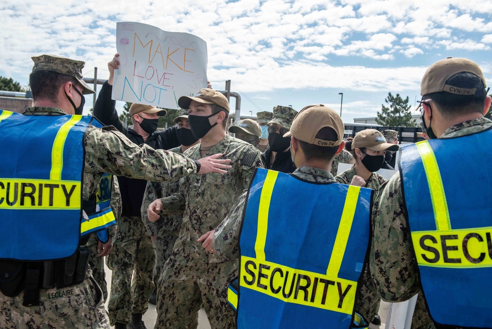 Sailors attempt to break through a line of security as part of an anti-terrorism training team drill