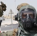 A U.S. Special Operations Forces member dons his protective, respirator mask and chemical resistant suit at a crisis scenario during IS 21