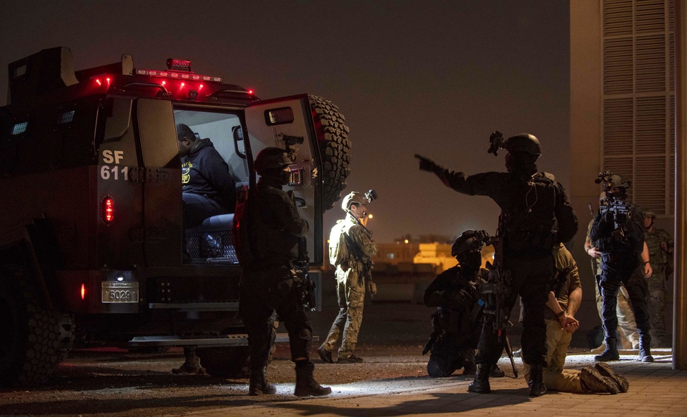 U.S. and Qatari Special Operations Forces prepare detainee role-players for transport during IS 21