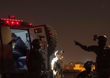 U.S. and Qatari Special Operations Forces prepare detainee role-players for transport during IS 21