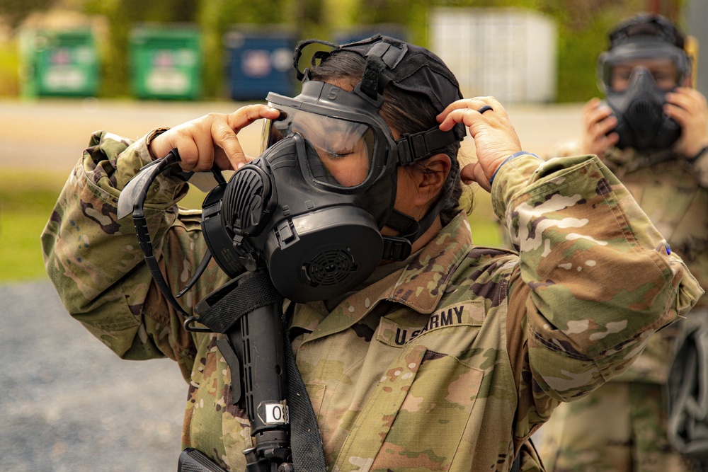 A Soldier places a PRO gas mask carefully on her face during a CBRN tutorial
