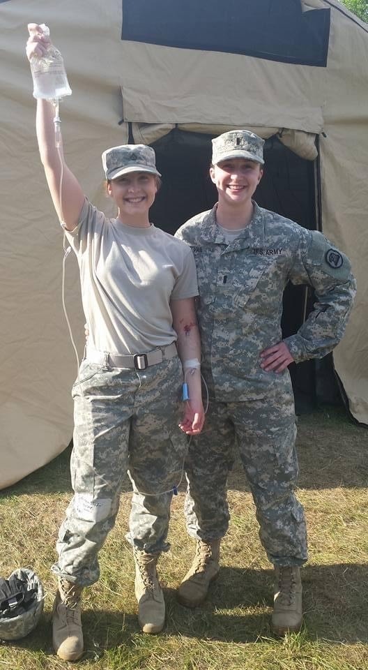 Pfc. Olivia Robinson, combat medic with the 294th Medical Battalion holds up an IV bag