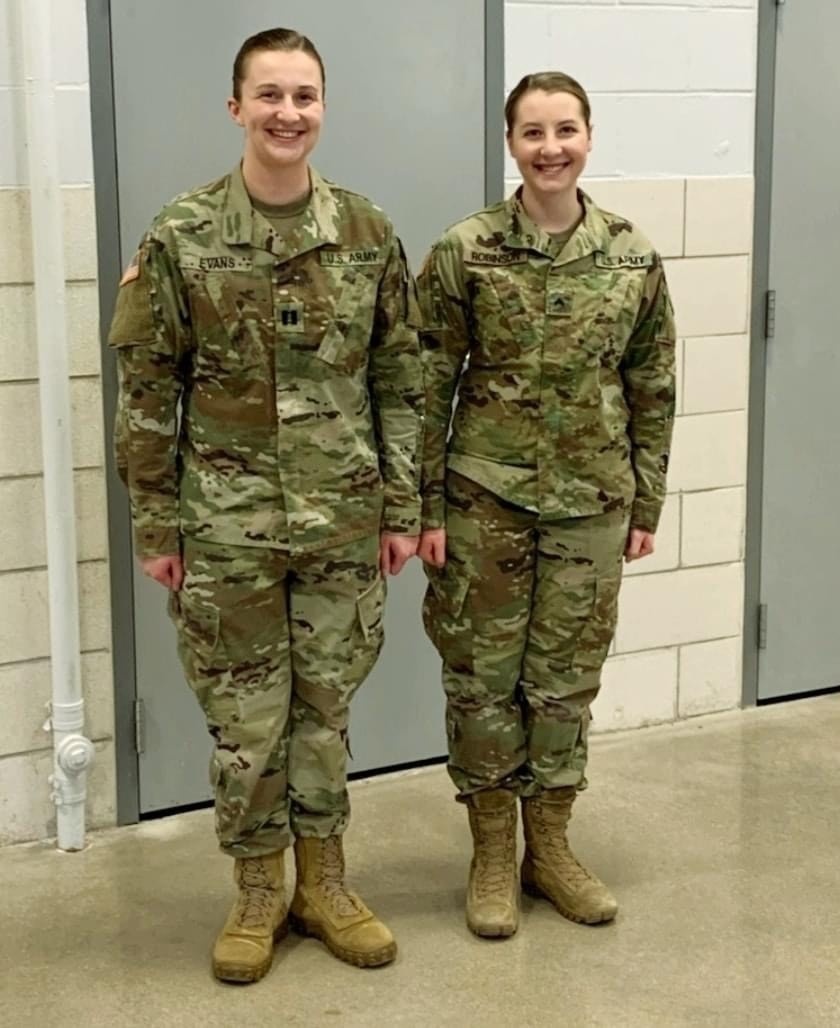 Sgt. Olivia Robinson, combat medic with the 294th Medical Battalion stands at attention next to her sister