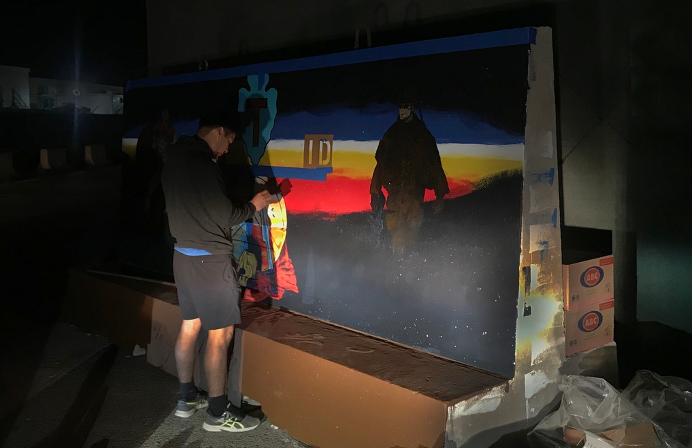 Task Force Spartan Soldier paints T-wall after winning design competition