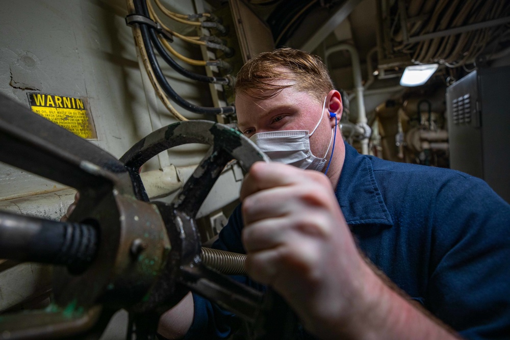Damage Controlman 3rd Class Nicklaus Umholtz conducts routine maitenance aboard the USS Barry