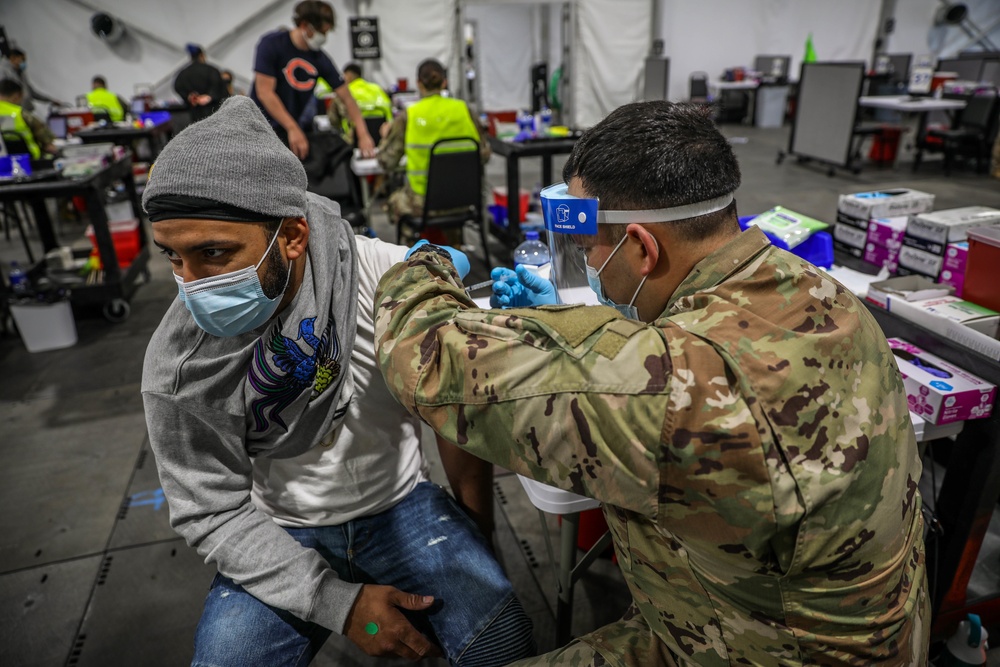 Soldier administers vaccine to his brother in Chicago