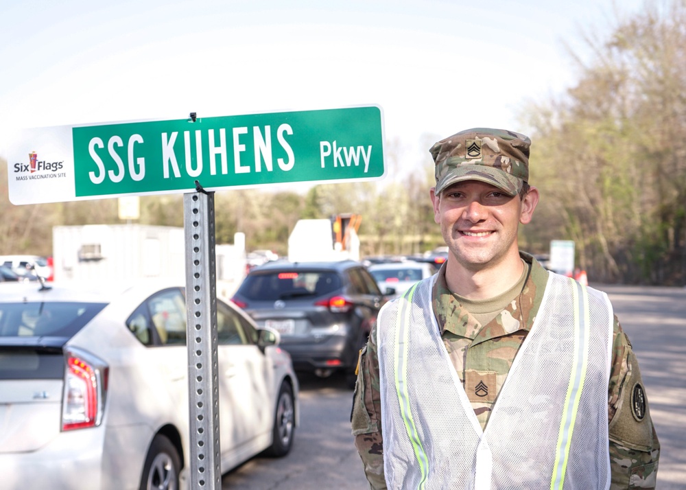 Staff Sgt. Kuhens next to his sign