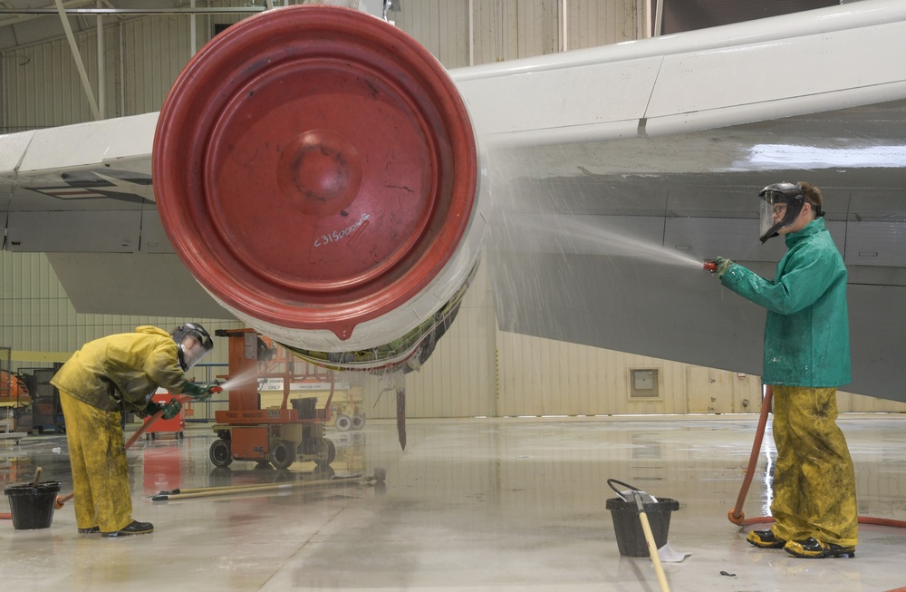 Photo of Team JSTARS personnel scrubbing aircraft in ISO Dock