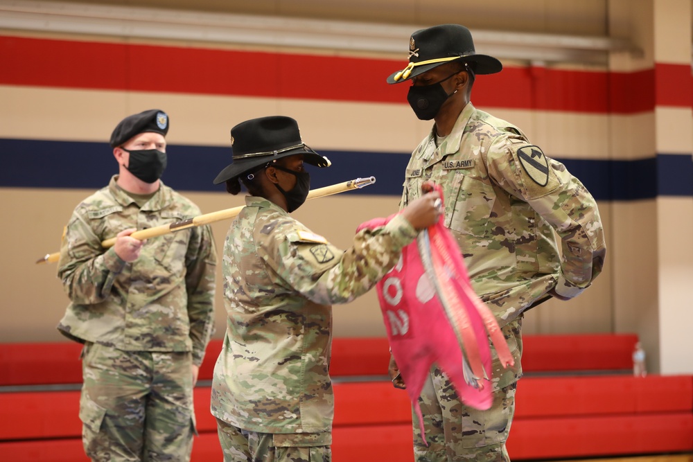 Capt. Neisha Bailey and 1st Sergeant Dameion Baylor remove the old 602 Maintanence Company guidon and install the new B Company guidon during the 553rd Division Sustainment Support Battalion conversion ceremony April 16 at Fort Hood.
