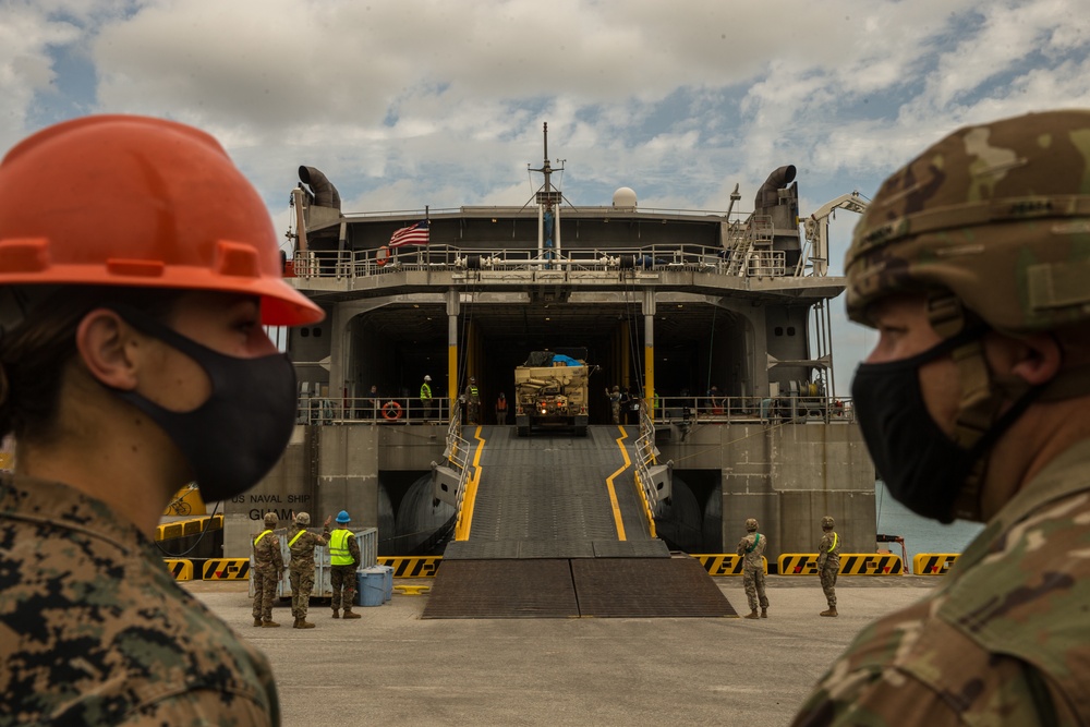 III Marine Expeditionary Force and U.S. Army 1st Battalion, 1st Air Defense Artillery, load cargo during Joint Mobility Exercise with USNS Guam