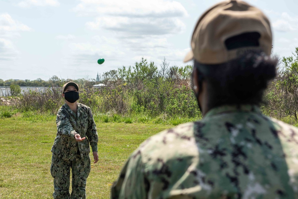 Sailors participate in an egg-tossing challenge during a Morale, Welfare, and Recreation Easter celebration event