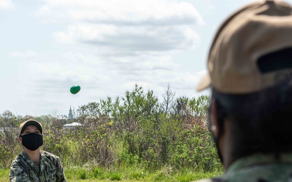 Sailors participate in an egg-tossing challenge during a Morale, Welfare, and Recreation Easter celebration event