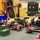The image shows a collection of red and black robotic systems and components labeled 'Army West Point' arranged on a gray foam mat in what appears to be an engineering lab or classroom. Multiple wheeled robots with mecanum wheels, robotic arms, and various mechanical components are displayed together. The equipment appears to belong to the Army West Point Department of Engineering robotics program.
