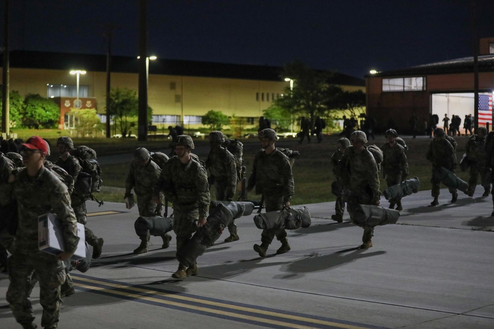 Paratroopers exit Pax Shed to load C-17