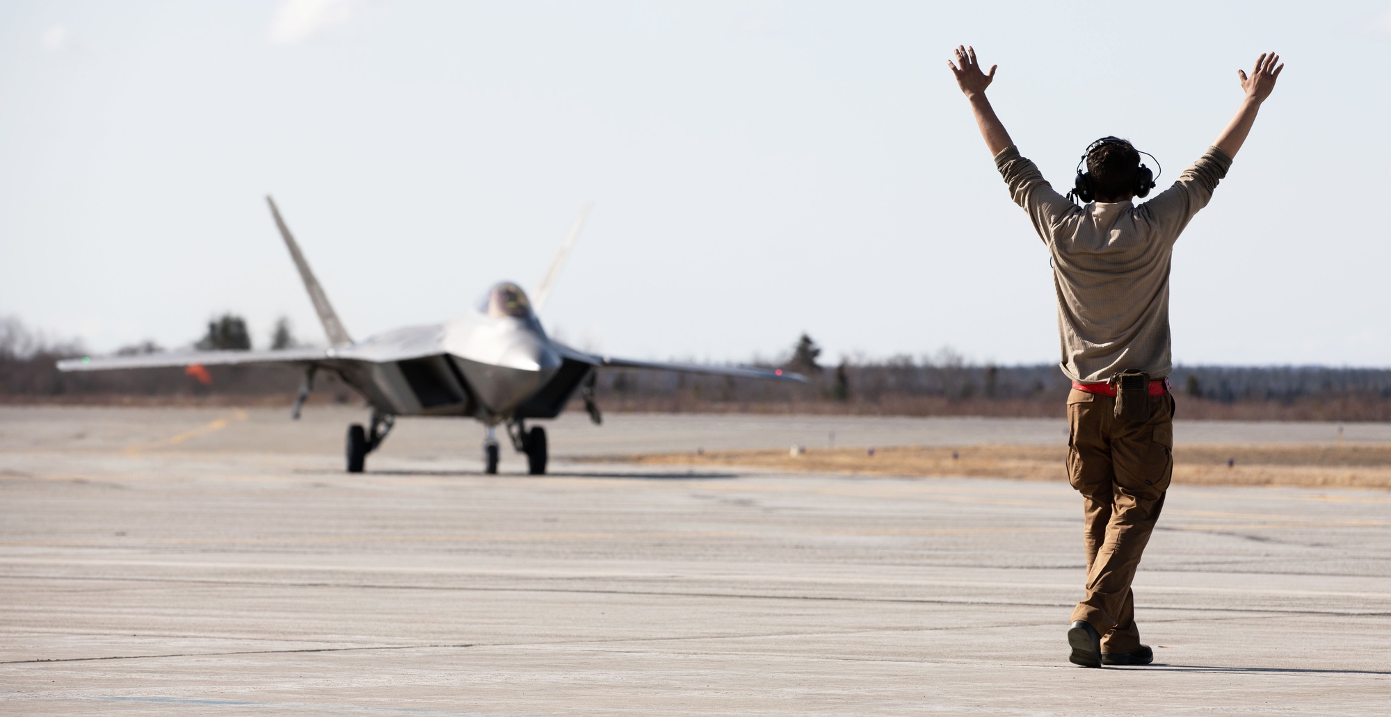 90th AMU Airman directs F-22 Raptor for maintenance during NE21