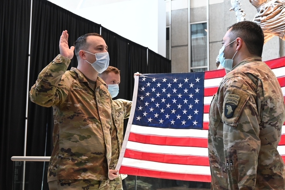 Staff Sgt. Chase Warren reenlists at the Michael Jordan statue at the United Center COVID-19 Community Vaccination Center, Chicago