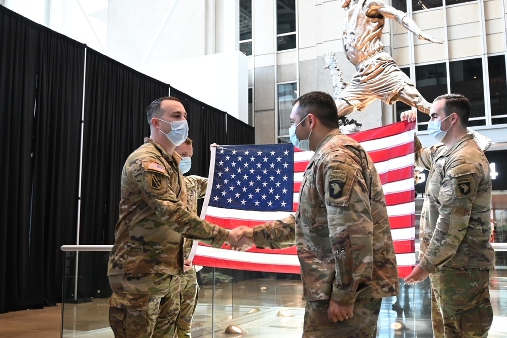 Staff Sgt. Chase Warren reenlists at the Michael Jordan statue at the United Center COVID-19 Community Vaccination Center, Chicago