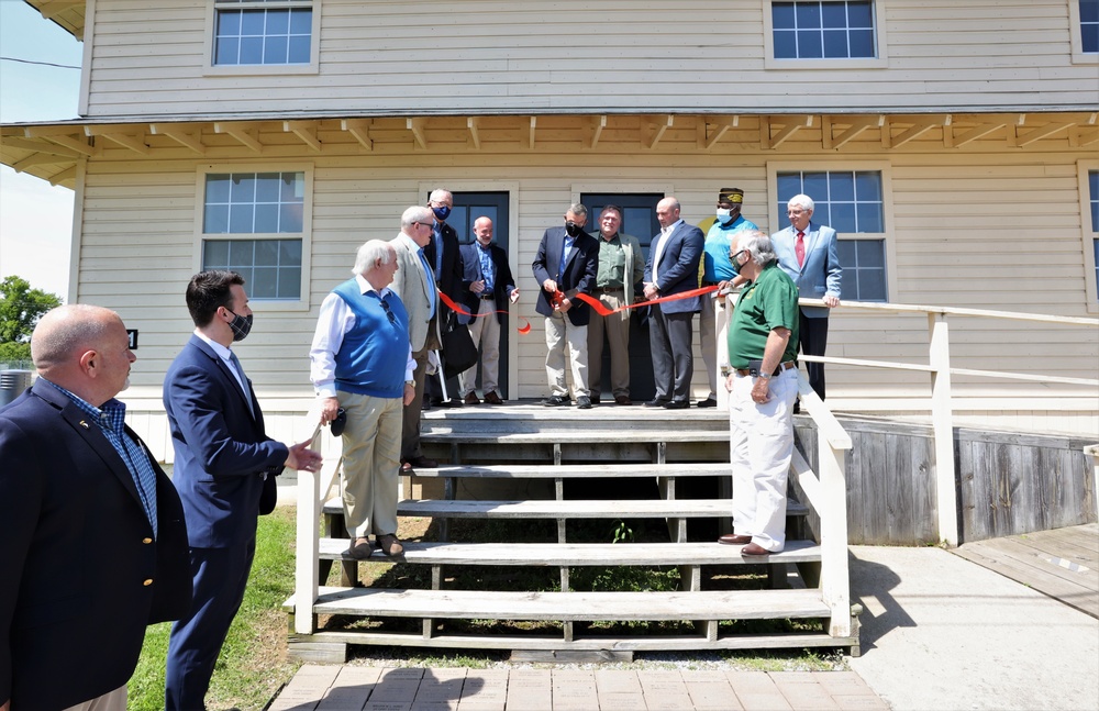 Retired Col. Mike Weaver cuts ribbon at WWII barracks grand opening