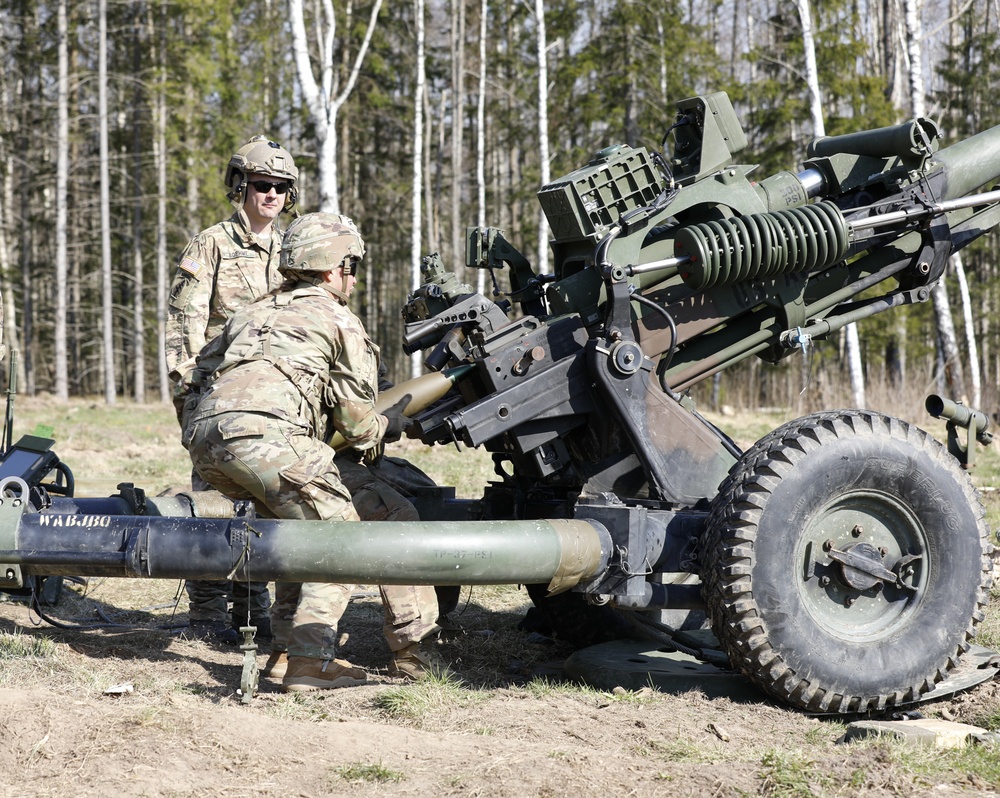 Soldier loads a 105 mm in the chamber