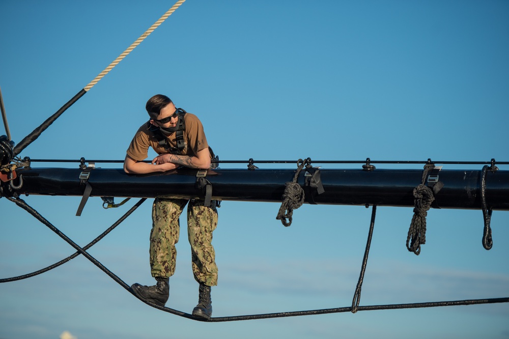 USS Constitution Sailors climb the mizzen top yard