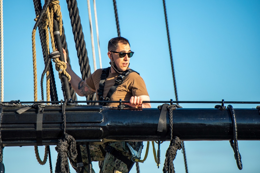 USS Constitution Sailors climb the mizzen top yard