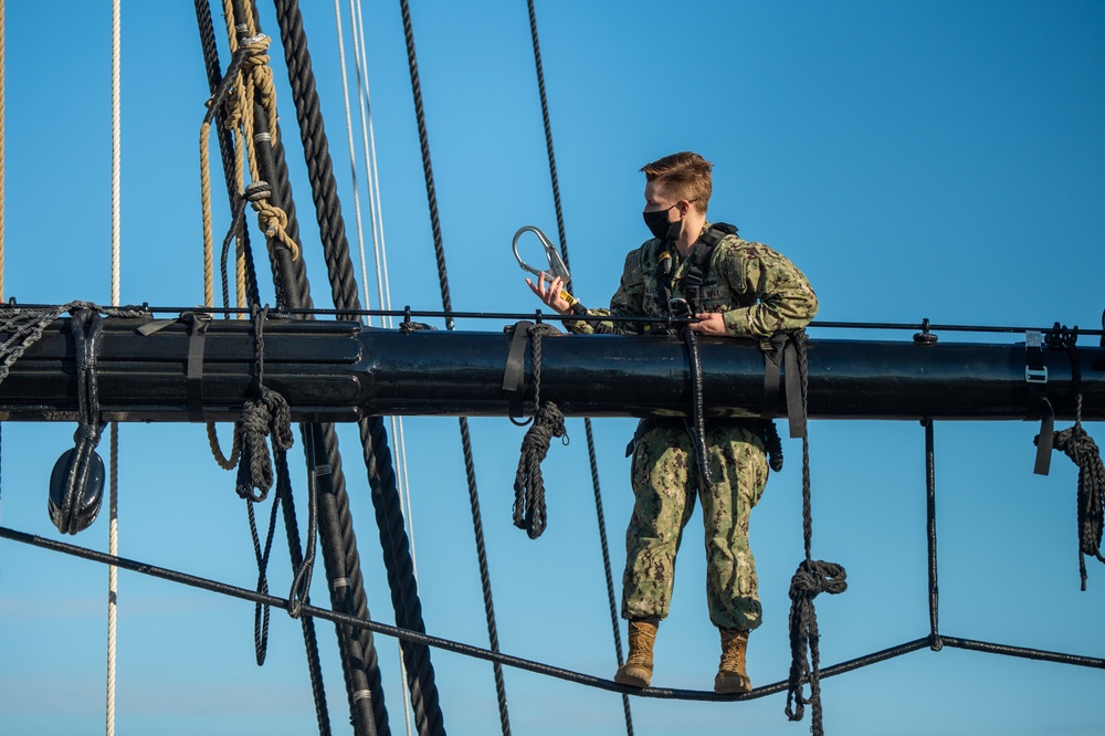 USS Constitution Sailors climb the mizzen top yard