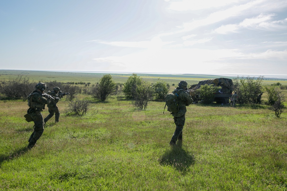 Soldiers maneuver to search a vehicle