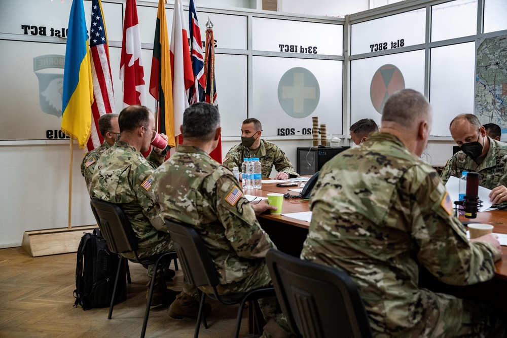 Lt. Gen. John S. Kolasheski, V Corps Commanding General, receives a brief on joint multinational group operations by the command team of Task Force Raven, 81st Stryker Brigade Combat Team, Washington Army National Guard, May 14, 2021
