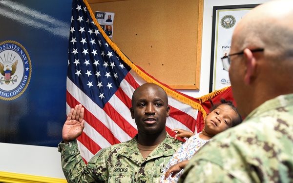 Commander, Navy Recruiting Command, RDML Dennis Velez, enlists Utilitiesman 1st Class Ivey Brooks for another four years at talent acquisition site Greensboro.