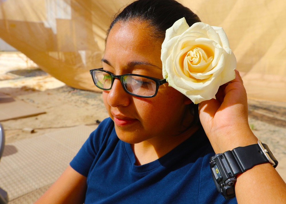 A Mother from 36th Infantry Division, Task Force Spartan, places a flower in her hair at Mother's Day celebration