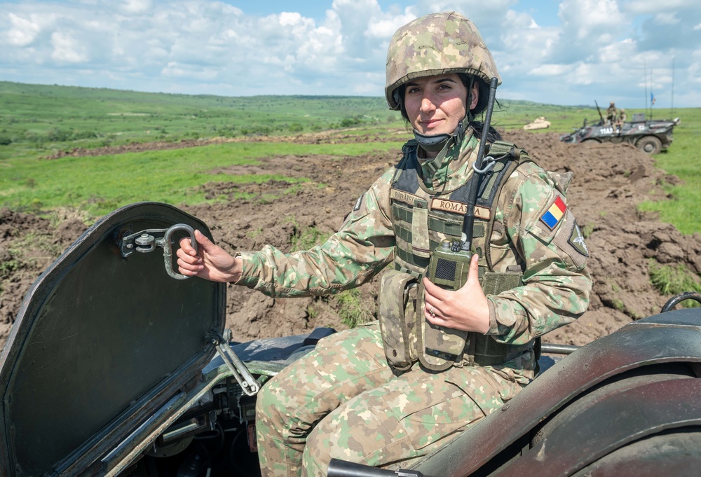 Romanian soldier from the Carpathian Eagles Battalion, operates an armoured vehicle while conducting tactical vehicle manoeuvring