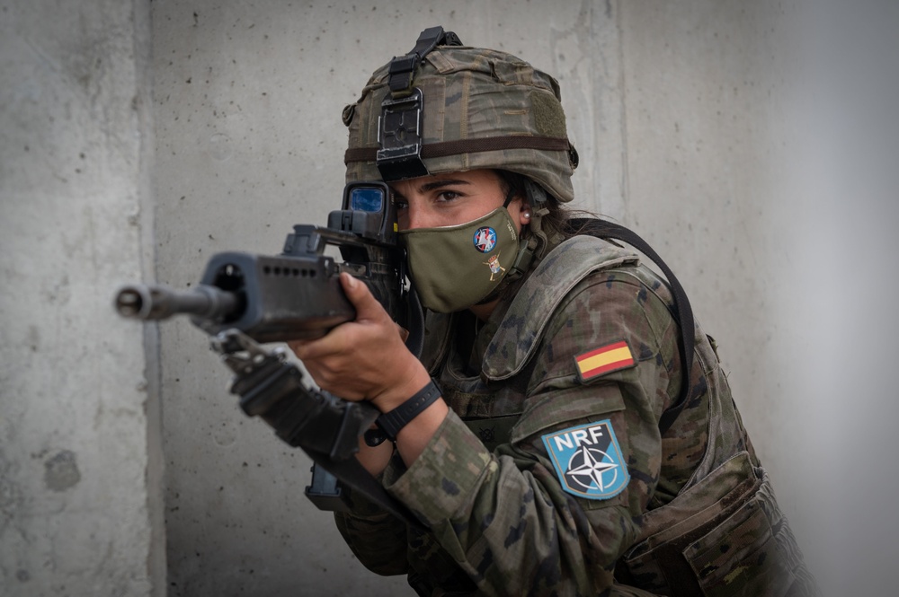 A Spanish Soldier assigned to the BRILAT Brigade aims her HK G36 rifle while holding her position conducting urban combat training during Exercise Steadfast Defender 2021
