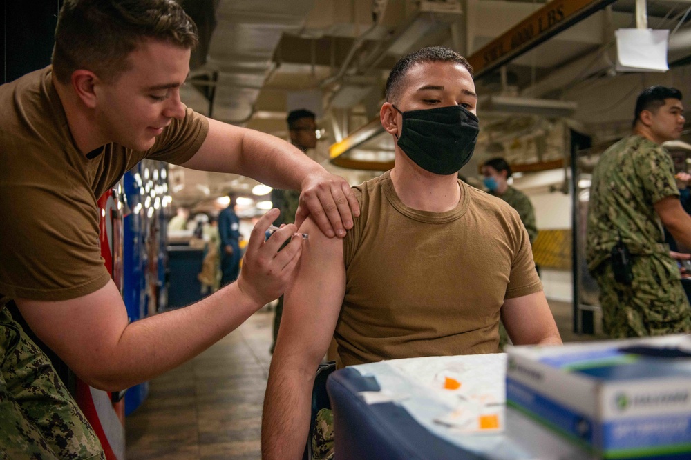 administers the COVID-19 vaccine