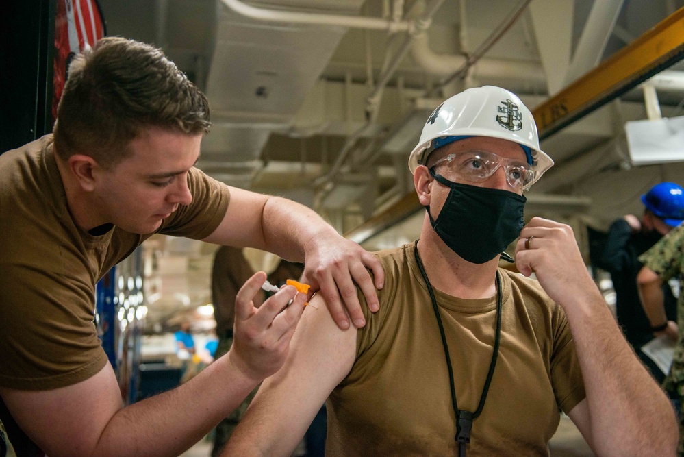 administers the COVID-19 vaccine