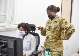 412th TEC SJA NCO discusses section battle rhythm with co-worker