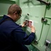 USS Sioux City Sailor Replaces Sign on Hatch