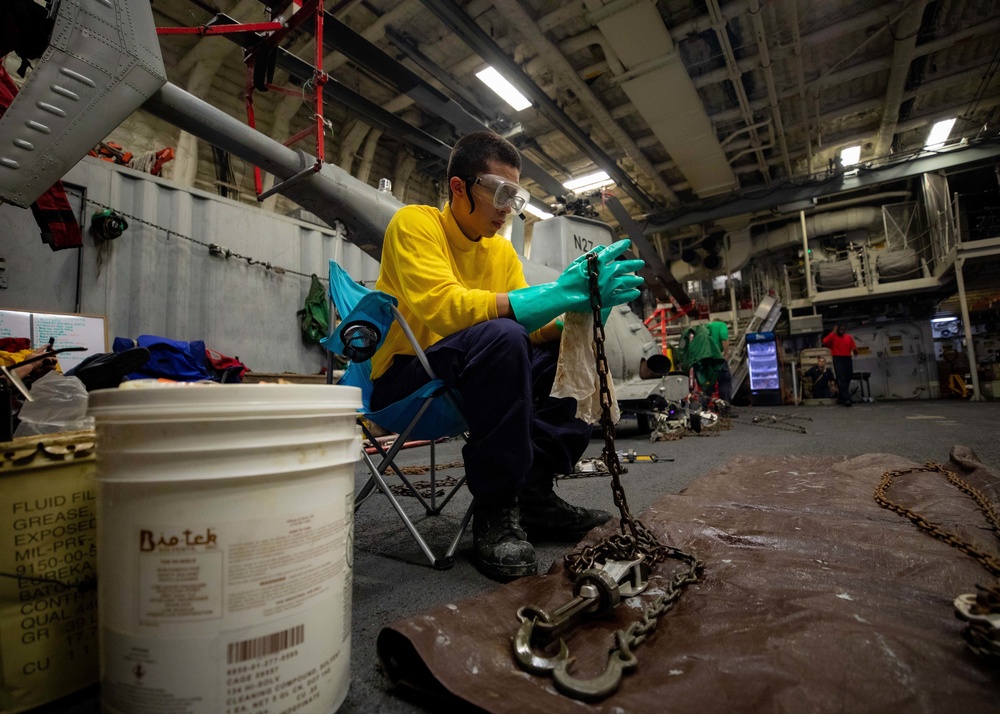 USS Sioux City Sailor Performs Maintenance on Tie-Down Chains