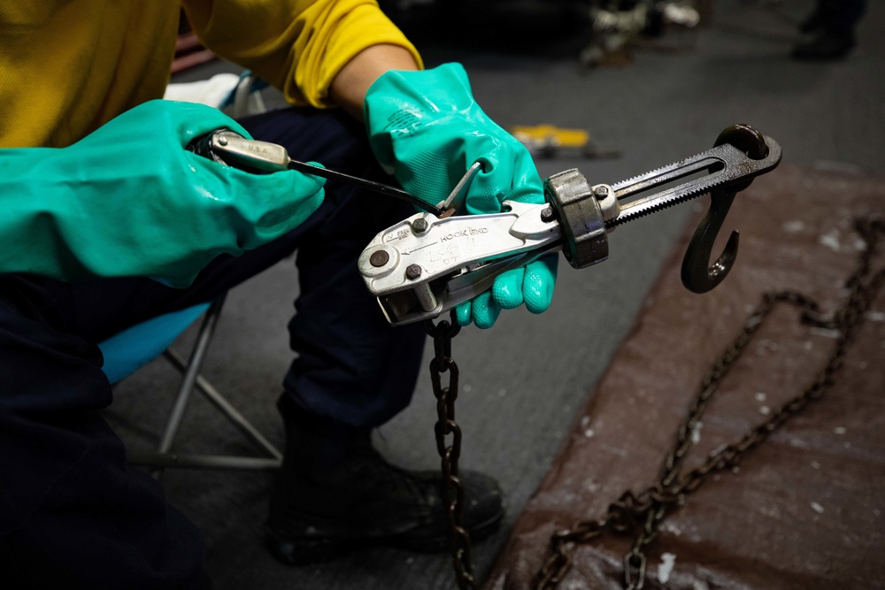 USS Sioux City Sailor Performs Maintenance on Tie-Down Chains