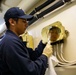 USS Sioux City Sailor Polishes Brass During Cleaning Stations