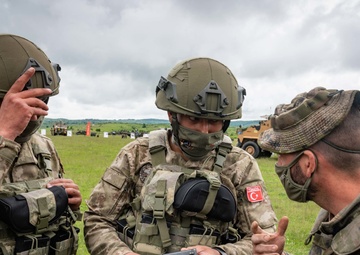 A Spanish Soldier shows his armory to Turkish troops at a static display of equipment during NATO Exercise Steadfast Defender 2021