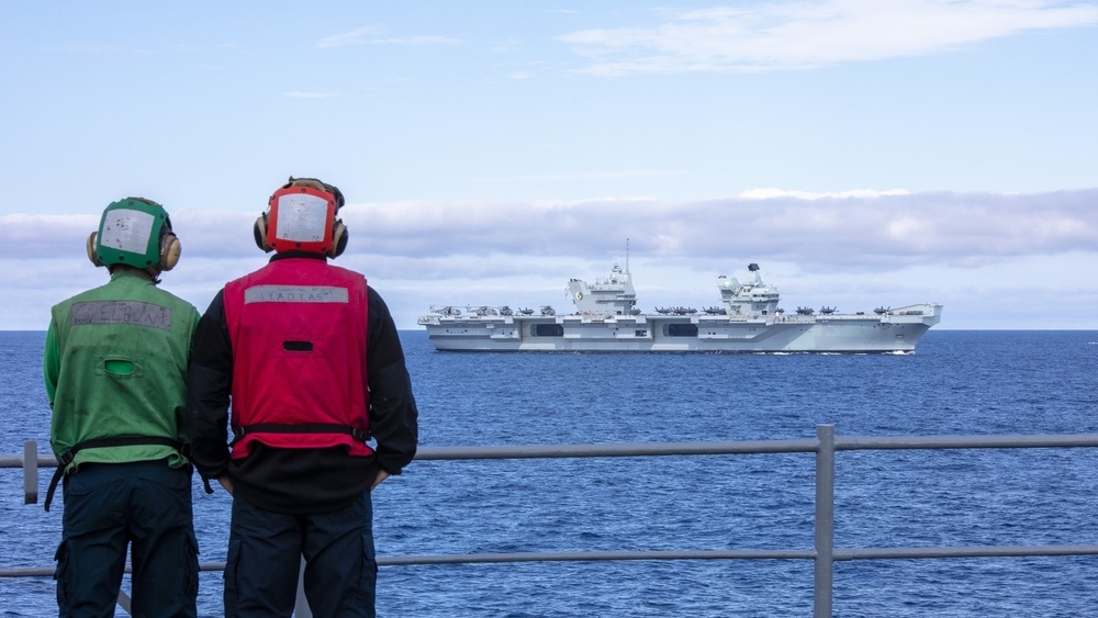 U.S. Navy Sailors observe the HMS Queen Elizabeth (R08) as it sails in formation in the Atlantic Ocean during Steadfast Defender 2021