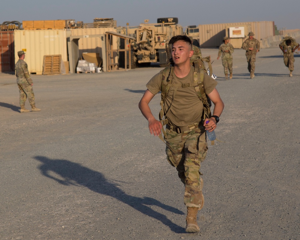 U.S. Army Spc. Destin Torres, Task Force Hellhound, runs to finish line of 12-Mile Ruck March portion of the TF Spartan Best Warrior Competition