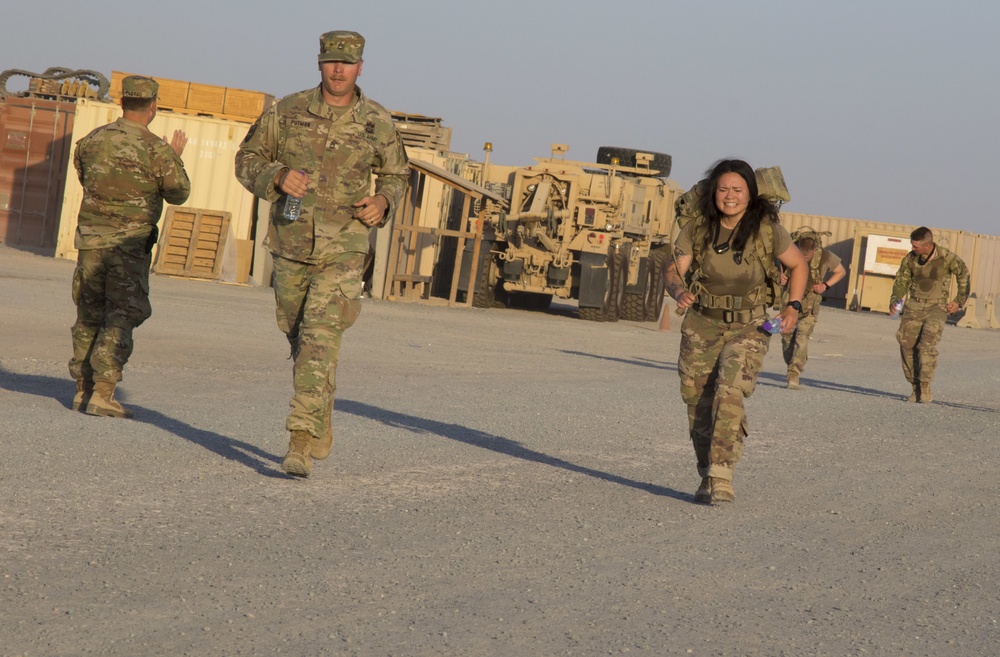 U.S. Army Sgt. Kaylamarie Hemm, Task Force Hellhound, steps toward finish line of 12-Mile Ruck March of TF Spartan Best Warrior Competition